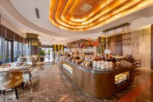 a restaurant with a bar with tables and chairs at Nesta Celia Danang Hotel in Danang