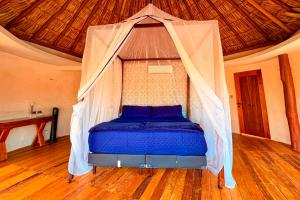 a bed with a mosquito net in a room at Cabanas Jaalkab in Chelem +73 photos