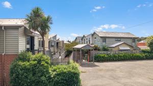 a row of houses with a fence and a palm tree at Sovereign Views Apartments in Ballarat