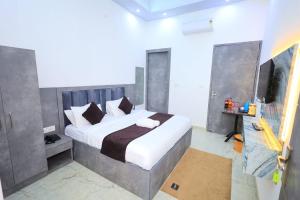 a bedroom with a large bed and a television at Hotel Yuvan Palace - Agra in Tājganj +11 photos