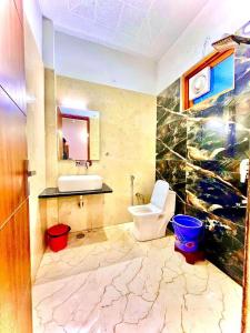 a bathroom with a white toilet and a sink at Hotel Yuvan Palace - Agra in Tājganj