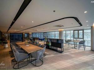 a dining room with a table and chairs and windows at The Song Vung Tau - Infinity Pool & Sea View - Căn Hộ Du Lịch Tháp Tam Thắng - HOUSES BY THE SEA in Vung Tau