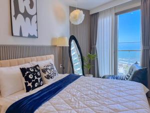 a bedroom with a bed and a large window at The Song Vung Tau - Infinity Pool & Sea View - Căn Hộ Du Lịch Tháp Tam Thắng - HOUSES BY THE SEA in Vung Tau +108 photos