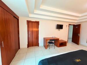 ein Zimmer mit Schreibtisch, Tisch und Fernseher in der Unterkunft Royal Express Chilpancingo in Chilpancingo de los Bravos + 32 Fotos