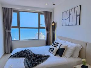 a bedroom with a bed with a large window at The Song Vung Tau - Infinity Pool & Sea View - Căn Hộ Du Lịch Tháp Tam Thắng - HOUSES BY THE SEA in Vung Tau