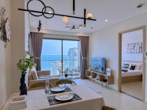 a living room with a couch and a dining room at The Song Vung Tau - Infinity Pool & Sea View - Căn Hộ Du Lịch Tháp Tam Thắng - HOUSES BY THE SEA in Vung Tau