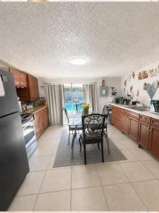 a kitchen with a table and a dining room at One-Bedroom Suite Pool with Bath Kitchen in West Palm Beach in West Palm Beach