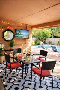 a patio with a table and chairs and a tv at One-Bedroom Suite Pool with Bath Kitchen in West Palm Beach in West Palm Beach
