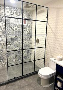 a bathroom with a toilet and a glass wall at Casa7Cielos in Monterrey