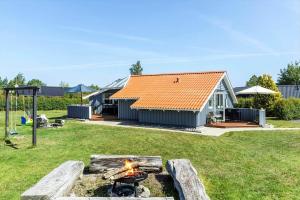 a house with a fire pit in the yard at FY141-Middelfart-Regulusvej-13 in Middelfart