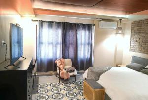a bedroom with a bed and a tv and a chair at Casa7Cielos in Monterrey