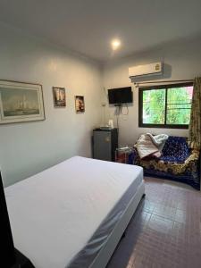a bedroom with a large white bed and a window at Hero Phuket in Nai Yang Beach