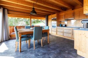 a kitchen with a wooden table and blue chairs at Chalet La Renarde in Villars-sur-Ollon