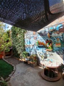 a patio with a table and a wall with graffiti at Deptosxdia in Perito Moreno