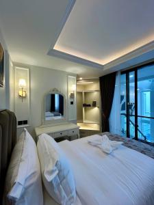 a bedroom with a large white bed and a television at Royal Classic Puncak in Cisarua +30 photos