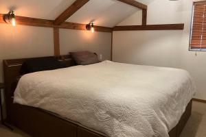 a bedroom with a white bed in a room at Chalet Tsugaike in Otari