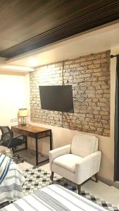 a living room with a couch and a tv on a brick wall at Casa7Cielos in Monterrey