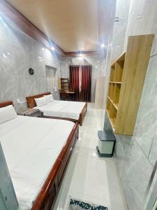 a room with two beds and a walk in shower at Tuan Thanh Homestay in Tân Hiệp +34 photos