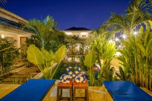 a resort patio with two chairs and palm trees at Drift Hideaway- Adult only in Kuta Lombok