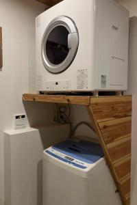 a washing machine sitting on top of a toilet at Chalet Tsugaike in Otari +17 photos