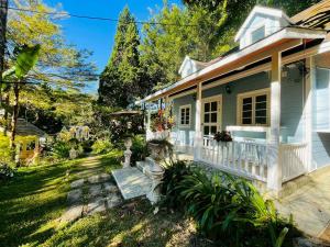 a white house with a porch and a yard at ปางสูงเฮาส์ pangsunghouse in Ban Pang Bo Hu Bon