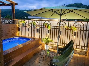 a patio with an umbrella and a swimming pool at Blue Sea and Sunny B&B in Toucheng