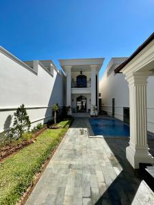 an exterior view of a house with columns and a swimming pool at Royal Classic Puncak in Cisarua