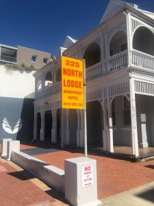 a yellow sign in front of a building at Northlodge Central City Apartments in Perth