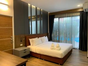 a bedroom with a bed with two towels on it at The RiverKwai Bridge Resort 2 in Ban Chuk Kum