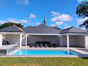 a swimming pool in the backyard of a house at Lila in La Chapelle-de-Brain