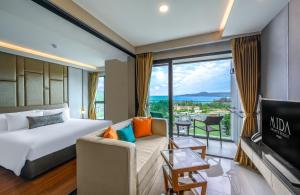 a hotel room with a bed and a view of the ocean at Mida Grande Resort Phuket Official Account in Surin Beach