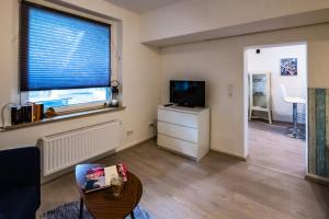 een woonkamer met een televisie en een raam bij Ferienwohnung Rath in Keulen