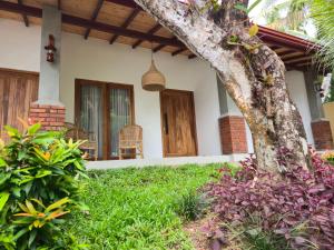 a front porch of a house with a tree at Villa Nutmeg Grove Galle in Galle