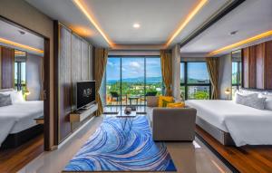 a hotel room with two beds and a blue rug at Mida Grande Resort Phuket Official Account in Surin Beach