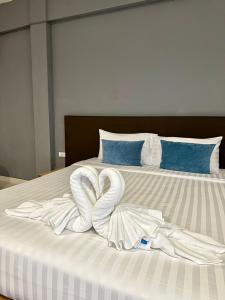a bed with two swans made out of towels at House Hotel Walking Street Pattaya in Pattaya +14 photos