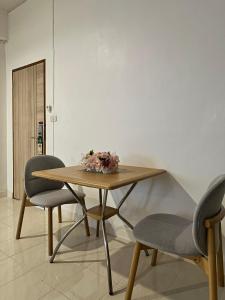 a table with two chairs and a flower arrangement on it at House Hotel Walking Street Pattaya in Pattaya