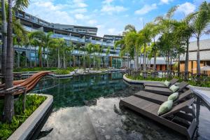 a resort with a pool with palm trees and a building at Mida Grande Resort Phuket Official Account in Surin Beach +102 photos