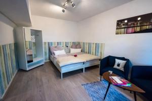 ケルンにあるFerienwohnung Rathのベッド1台とソファが備わる小さな客室です。