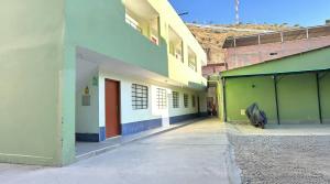 a group of buildings with different colored walls at Hostal La Huerta in Huánuco
