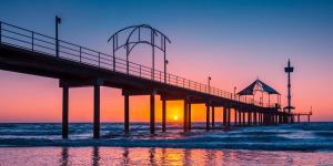 a pier at the beach at sunset at Seaside Adelaide Holiday Apartment 2BR 1 min walk to Brighton Beach in Adelaide +6 photos
