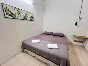 a bed in a room with two towels on it at Solehah Homestay in Seri Iskandar