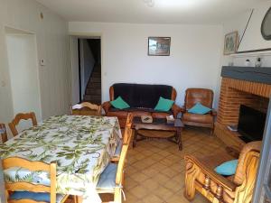 a living room with a table and chairs and a fireplace at Gîte des deux Moulins en Périgord Vert in Grand Brassac