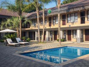 a hotel with a swimming pool in front of a building at Europrime Hotels Lakefield in Benoni