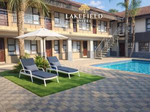two chairs and an umbrella in front of a hotel at Europrime Hotels Lakefield in Benoni