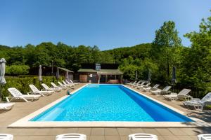 a swimming pool with chaise lounge chairs and a resort at Kalabash Apartments in Sovata