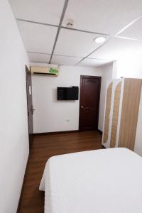 a room with a bed and a tv on the wall at Hotel de Alborada - Cerca Del Aeropuerto in Guayaquil +38 photos