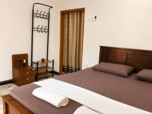 a bedroom with a large bed with a wooden frame at MG Home Sigiriya in Inamaluwa