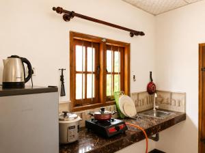 a kitchen with a counter top with a sink and a stove at MG Home Sigiriya in Inamaluwa