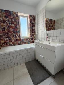 a white bathroom with a tub and a sink and a bath tubermott at Elegant Garden Villa American Village Pipera in Voluntari +42 photos