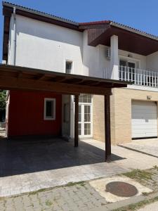a house with a garage and a driveway at Elegant Garden Villa American Village Pipera in Voluntari